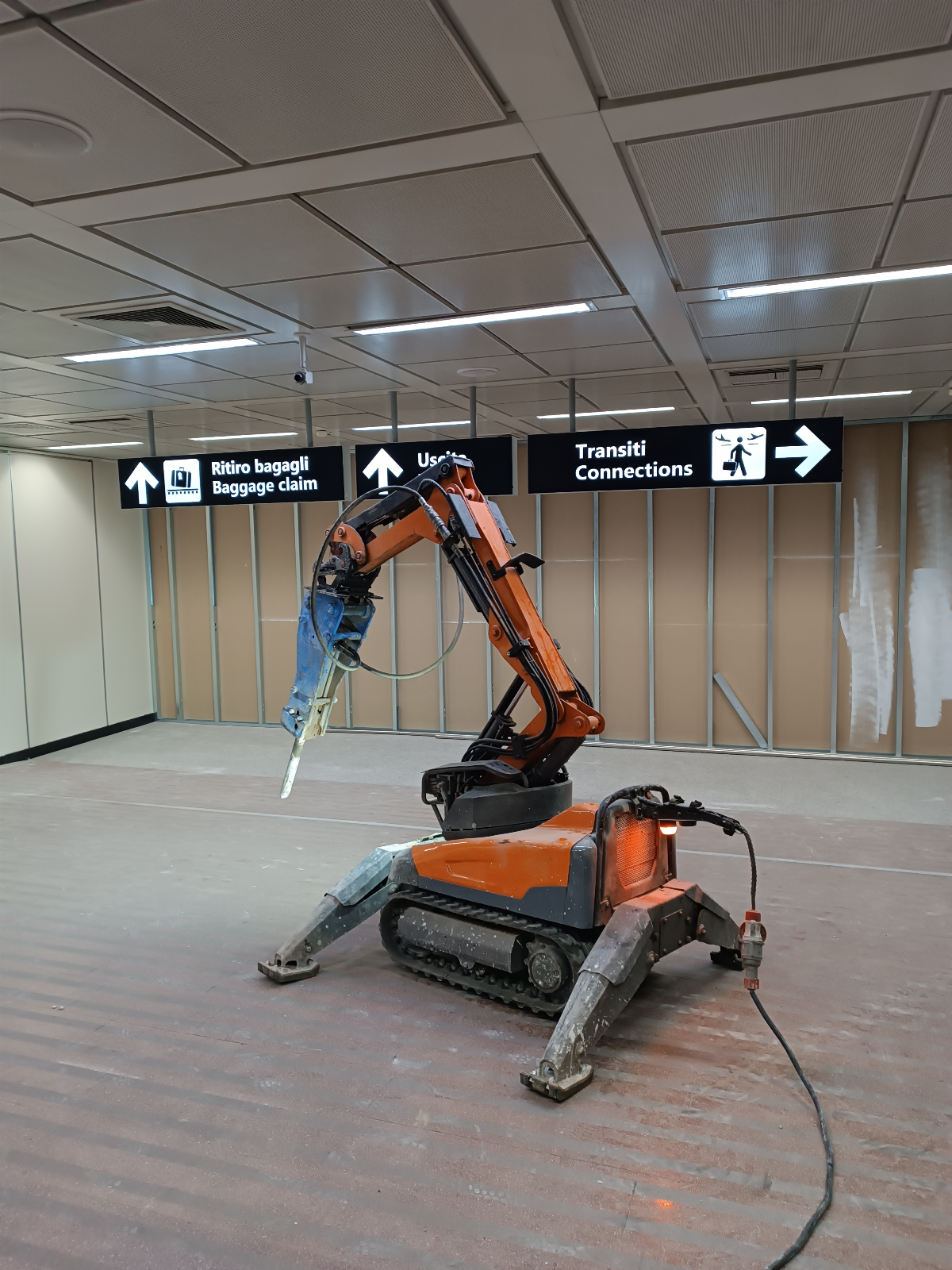 Escavatore elettrico radiocomandato a controllo remoto dotato di martello presso aeroporto Roma Fiumicino per demolizione rampe di accesso