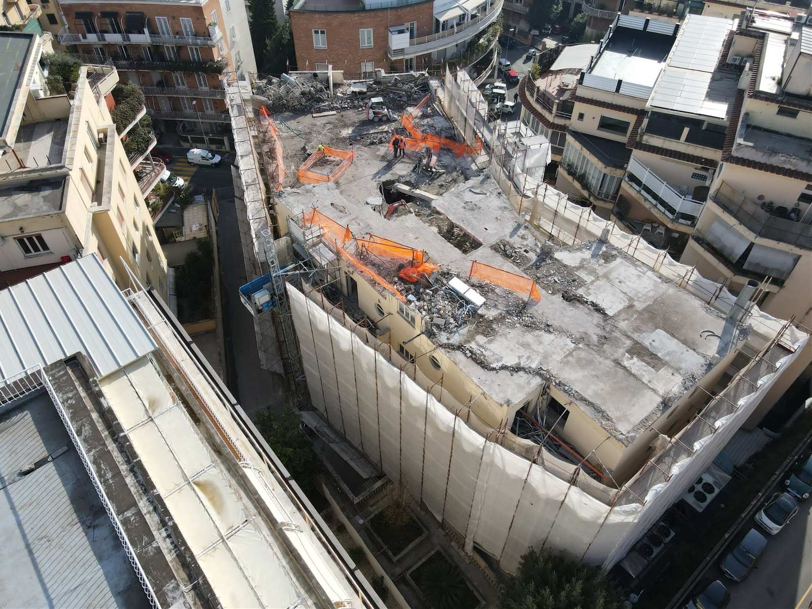 Panoramica della demolizione controllata con drone del Duke Hotel effettuata con robot radiocomandato escavatori e minipale